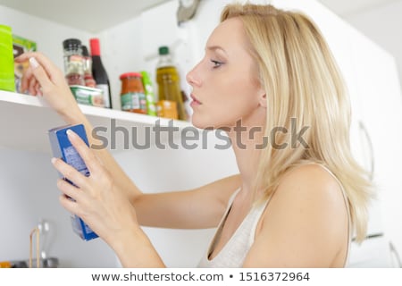 Сток-фото: Woman Looking For Food In The Cupboards