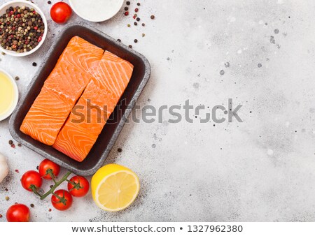 Stockfoto: Plastic Container With Fresh Salmon Slice With Oil Tomatoes And Lemon On Stone Kitchen Background S