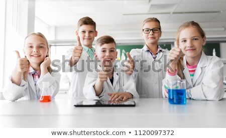 Foto stock: Happy Kids Showing Thumbs Up At School Laboratory