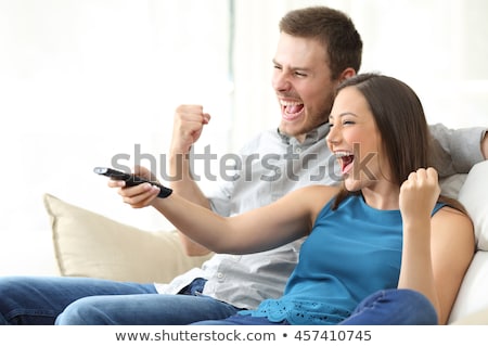 Stok fotoğraf: Teenagers Watching Television And Using Remote Control