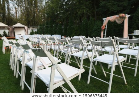 Stockfoto: Rows Of White Folding Chairs On Lawn