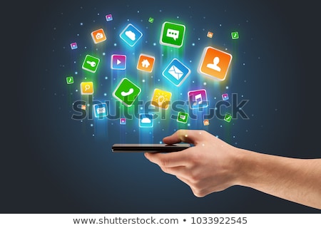 Stok fotoğraf: Hand Using Phone With Application Icons Flying Around