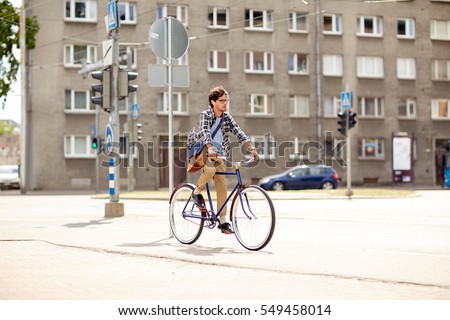 Foto stock: Young Hipster Man With Bag Riding Fixed Gear Bike