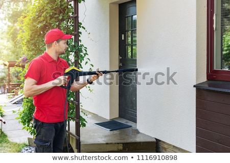 Stock fotó: Worker With High Pressure Washer Cleaning House Facade