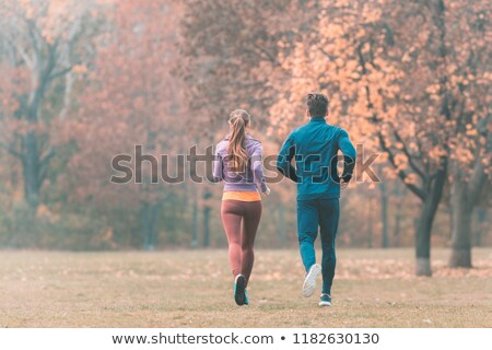 Stockfoto: Fall Running In A Park Seen From Behind Couple