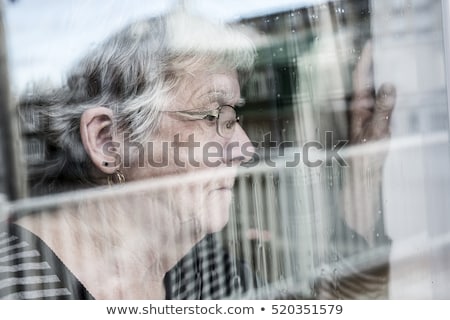 Senior Woman Looking Out Through A Window Like Depress ストックフォト © Lopolo