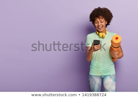 Stock photo: Happy African Sportswoman Posing And Listening To Music From Smartphone