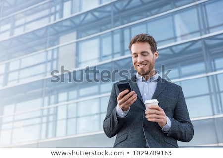 Stok fotoğraf: Business Man Looking At Phone Texting Sms Message Text Drinking Coffee On Morning Break At Work Offi
