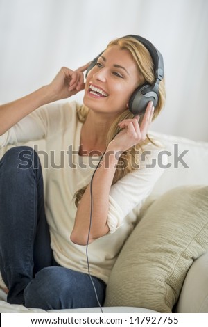 Stockfoto: Woman Listening To Mp3 Player On Headphones Relaxing Sitting On