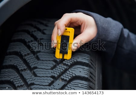 Stockfoto: Measuring The Depth Of A Tire Tread Or Profile