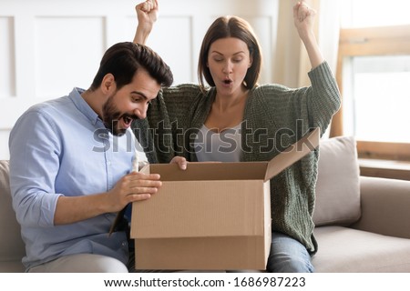 Stock foto: Happy Couple With Open Parcel Box At Home