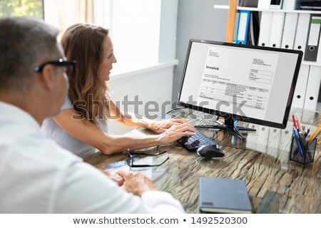 Stock photo: Two Businesspeople Checking Invoice In Office