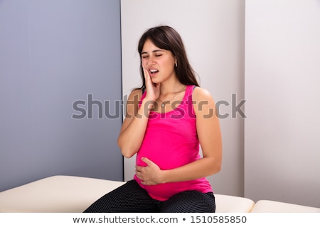 Stockfoto: Pregnant Woman Suffering From Toothache In Clinic