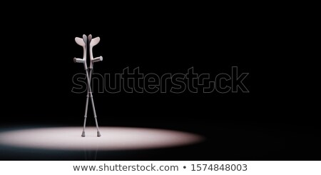 Stockfoto: Crutches Spotlighted On Black Background