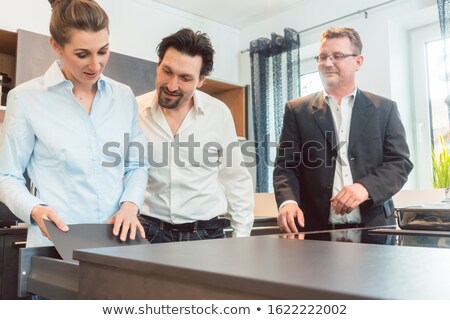 Stock fotó: Salesman Explaining Details Of New Kitchen To Couple