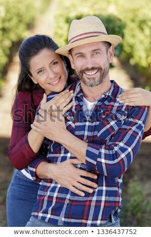 Foto stock: Couple Sat By Basket Full Of Grapes