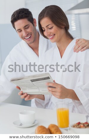 Stockfoto: Woman In Bathrobe Reading Newspaper