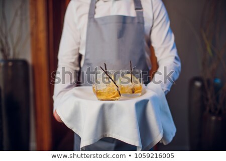 ストックフォト: Smiling Man Serving Whiskey With Ice On Silver Tray