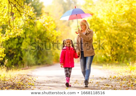 Сток-фото: Mother And Her Daughters With Umbrellas In Spring Alley