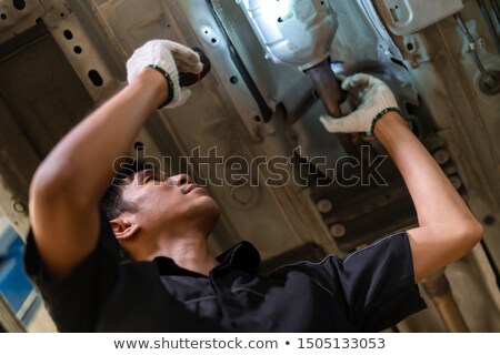 Stock fotó: Mechanic At Work On The Suspension System Of A Car