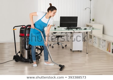 ストックフォト: Female Janitor Using Vacuum Cleaner On Floor