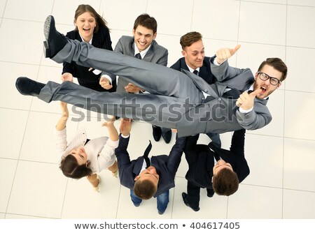 Stockfoto: Colleagues Toss Up Businessman