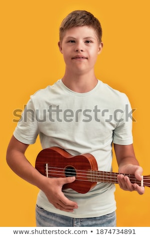 Stok fotoğraf: Front View Of Caucasian Boy Looking At Camera While Playing Guitar In A Classroom At Elementary Scho