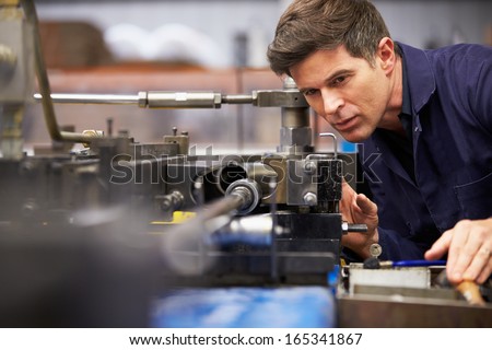 Foto stock: Male Engineer Working On Machine In Factory