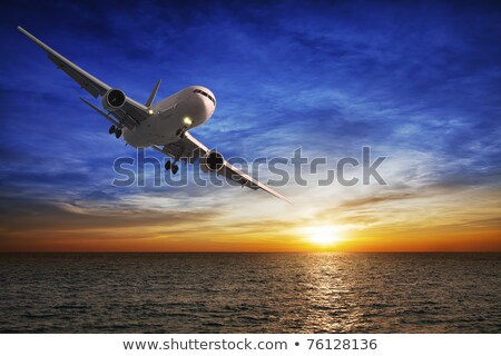 Stok fotoğraf: Evening Flight Jet Plane Over The Sea At Sunset