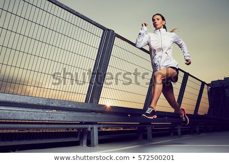 Stockfoto: Beautiful Female Jogger Running During Sunset