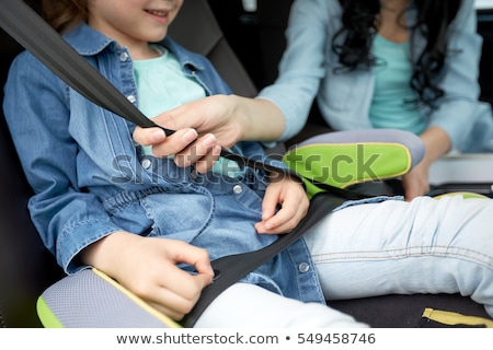 Сток-фото: Happy Woman Fastening Child With Seat Belt In Car