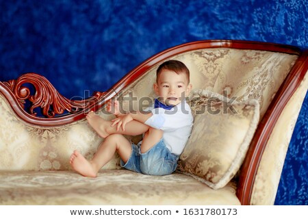 Foto d'archivio: The Boy 4 5 Years Asian Looks Dressed As A Gentleman And Sits On The Sofa