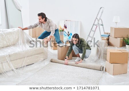 A Couple Rolling Out A Rug Stockfoto © Pressmaster