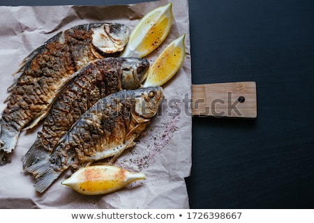 ストックフォト: Grilled Carp With Lemon Slices On A Wooden Board