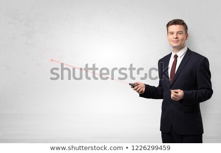 Foto d'archivio: Businessman With Laser Pointer And Copyspace White Wall