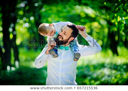 Foto stock: Man And Young Boy His Son Sitting Outdoors