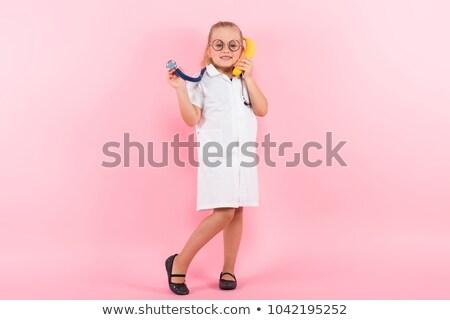 Foto d'archivio: Little Girl In Doctor Costume With Banana