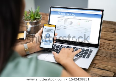 Foto stock: Woman Using Device To Authenthificate Bank Transfer
