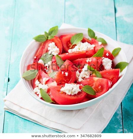 Foto stock: Tomato Salad With Basil Cheese Olive Oil And Garlic Dressing Blue Wooden Background Top View
