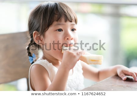 Beautiful Young Girl Sitting Eating Sweets Foto d'archivio © szefei