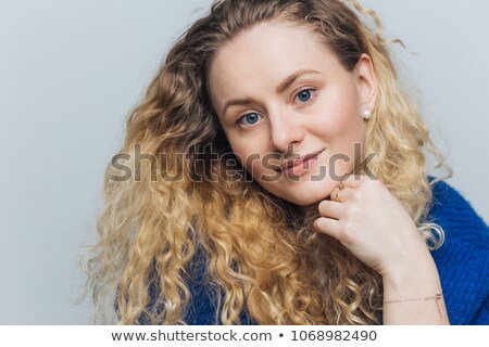 Stock fotó: Headshot Of Adorable Blue Eyed Female Model With Curly Hair Blue Eyes Holds Chin Looks With Pleas