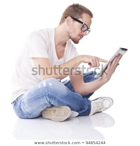 Foto d'archivio: Good Looking Smart Nerd Man With Tablet Computer And Book On Scr