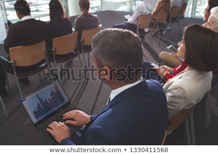 Foto stock: High Angle View Of Mixed Race Businessman Using Laptop During Business Seminar In Office Building