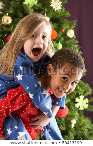 Stock photo: Two Young Children Having Fun In Front Of Christmas Tree