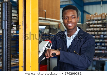 Zdjęcia stock: Factory Worker Using Powered Fork Lift To Load Goods