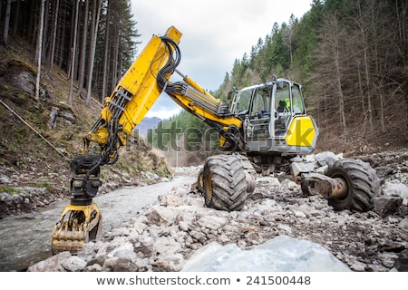 Stock photo: Wheeled Excavator In A River In The Autumn Forest Mountains