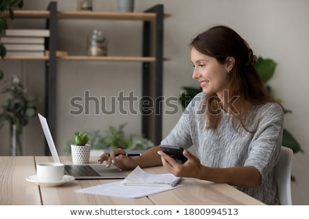 Zdjęcia stock: Candid Image Of A Young Woman Using Smartphone And Makes Notes I