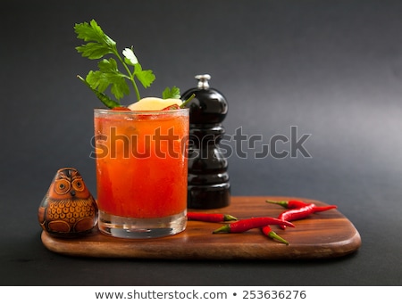 Foto d'archivio: Red Bloody Mary Drinks With Ice Cubes With Celery Isolated On Black