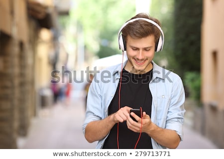 Foto stock: Handsome Guy Listening To Music On Internet With Smartphone