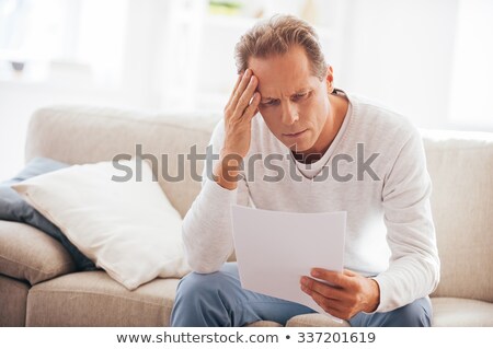 Foto stock: Bad News Depressed Mature Man Holding Paper